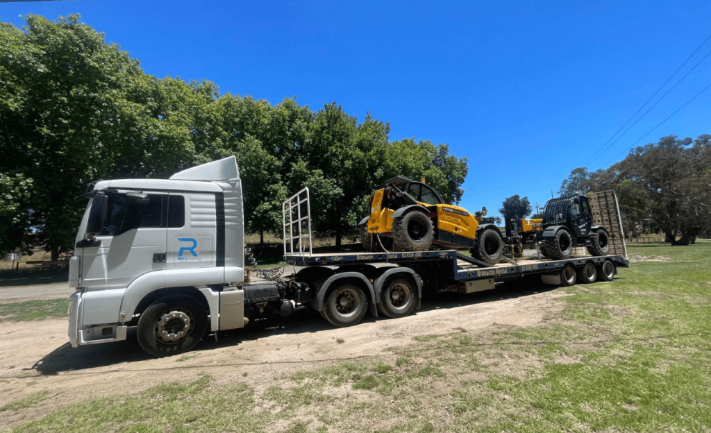 A Roc's Towing heavy haulage truck transporting two telehandlers for United Equipment.